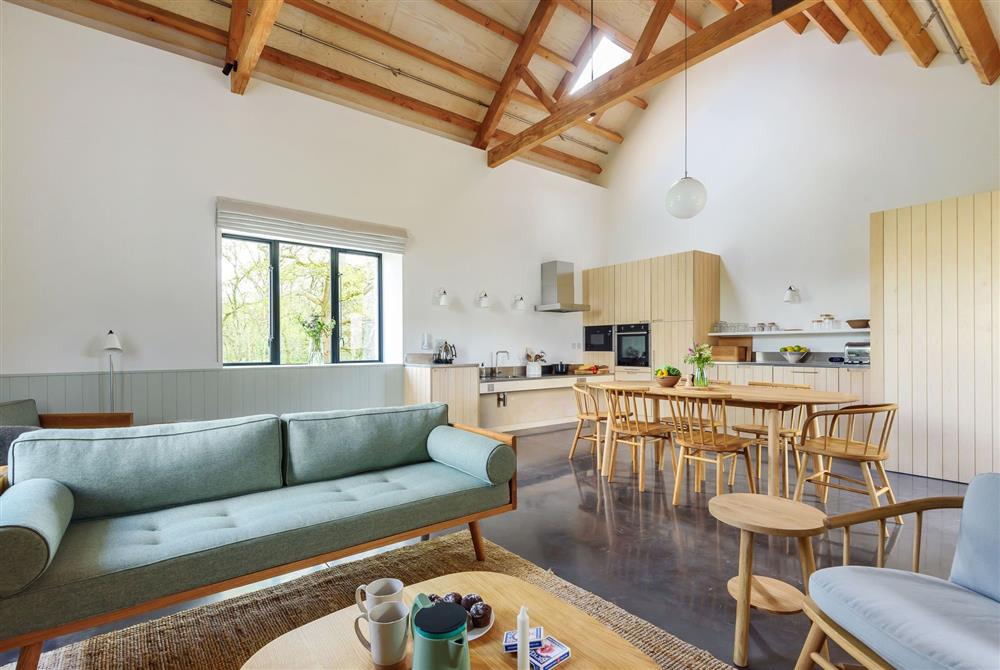 The open-plan sitting, dining and kitchen area with exposed beams throughout at Clementine, Dorchester