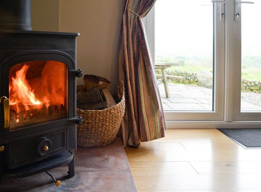 Unwind by the cosy woodburner at Cleughbrae Cottage in Dalry, near Castle Douglas, Kirkcudbrightshire