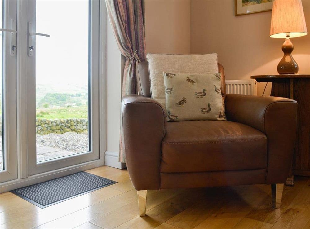 Welcoming living room with patio doors to the garden at Cleughbrae Cottage in Dalry, near Castle Douglas, Kirkcudbrightshire