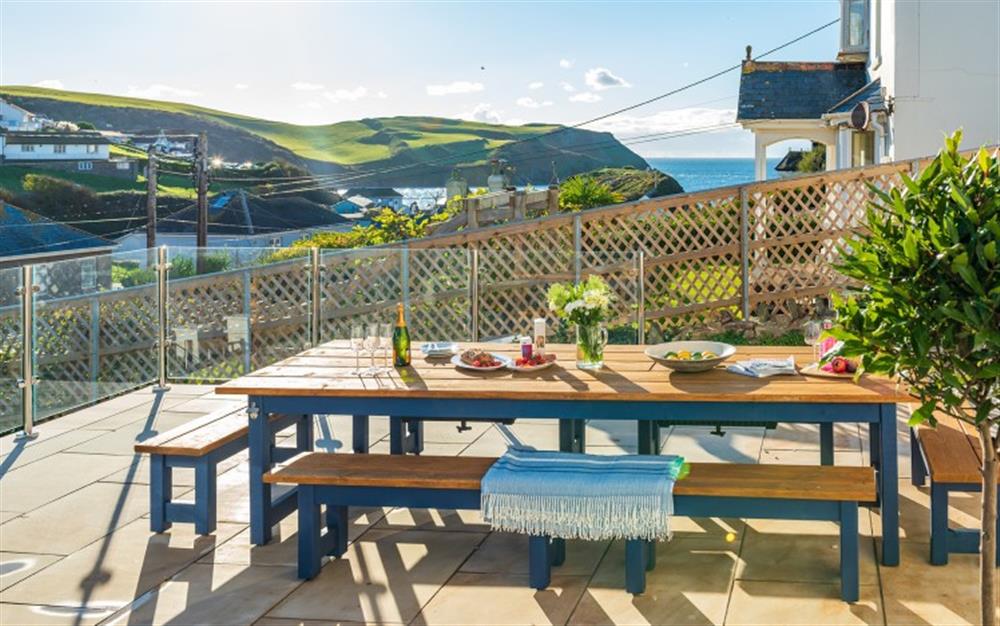 The large outside dining table, with built in bottle holders, and glorious sea views!  at Clevedon in Hope Cove