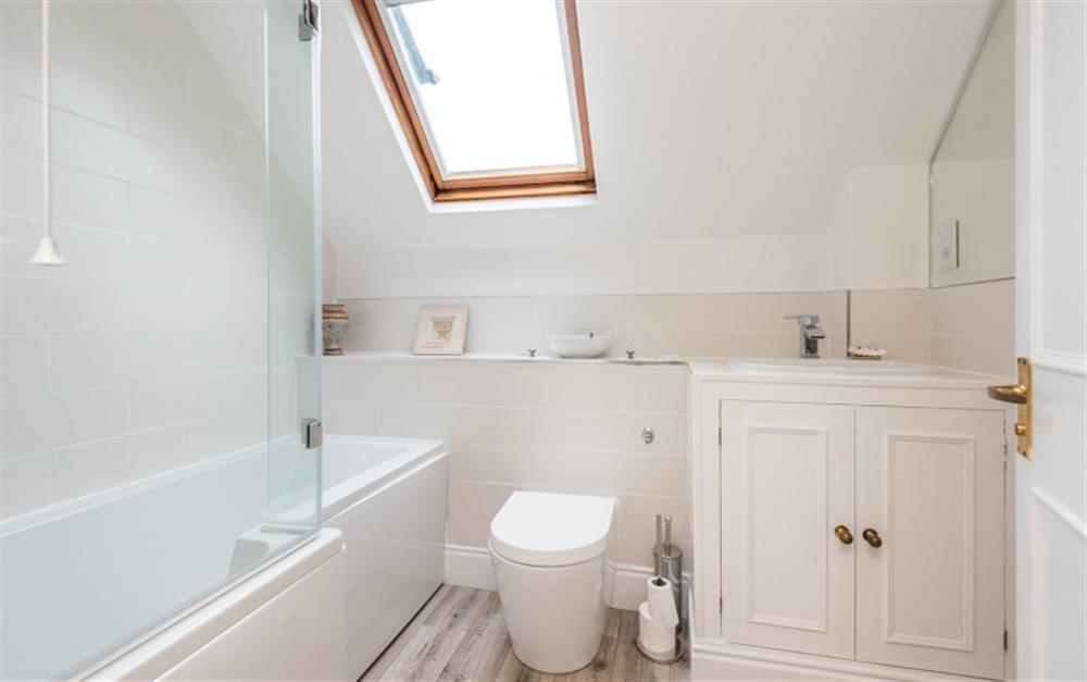 First floor ensuite bathroom with bath and shower over at Clock Cottage in Dittisham