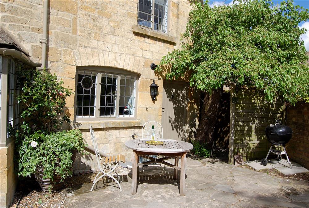 Sunny seating area, perfect for a summer barbecue at Closes Farm Cottage, Broadway