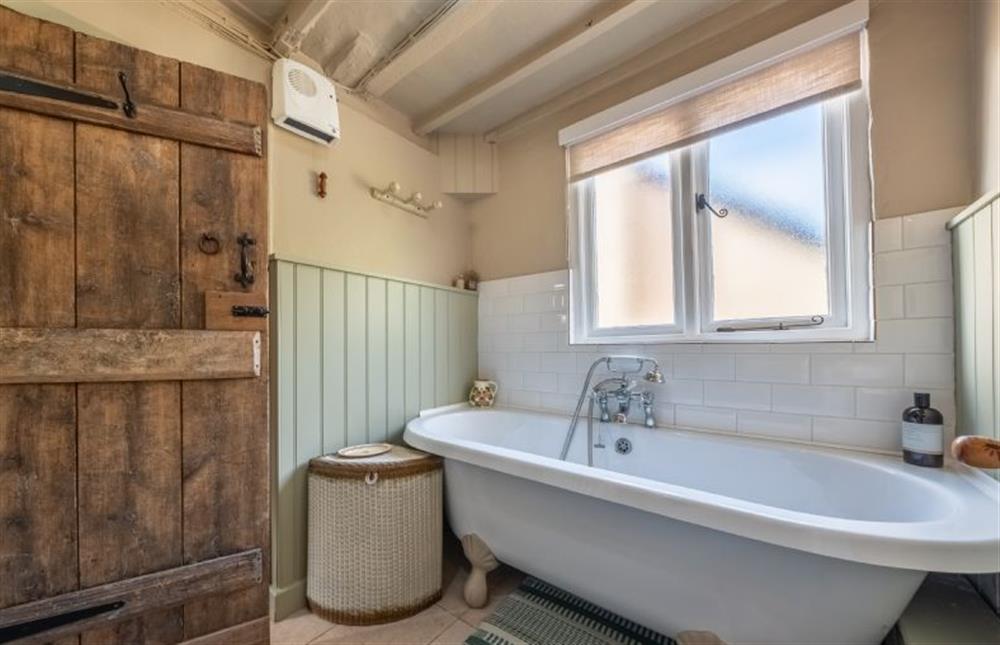 Bath with handheld shower head at Cloudberry Cottage, Coddenham