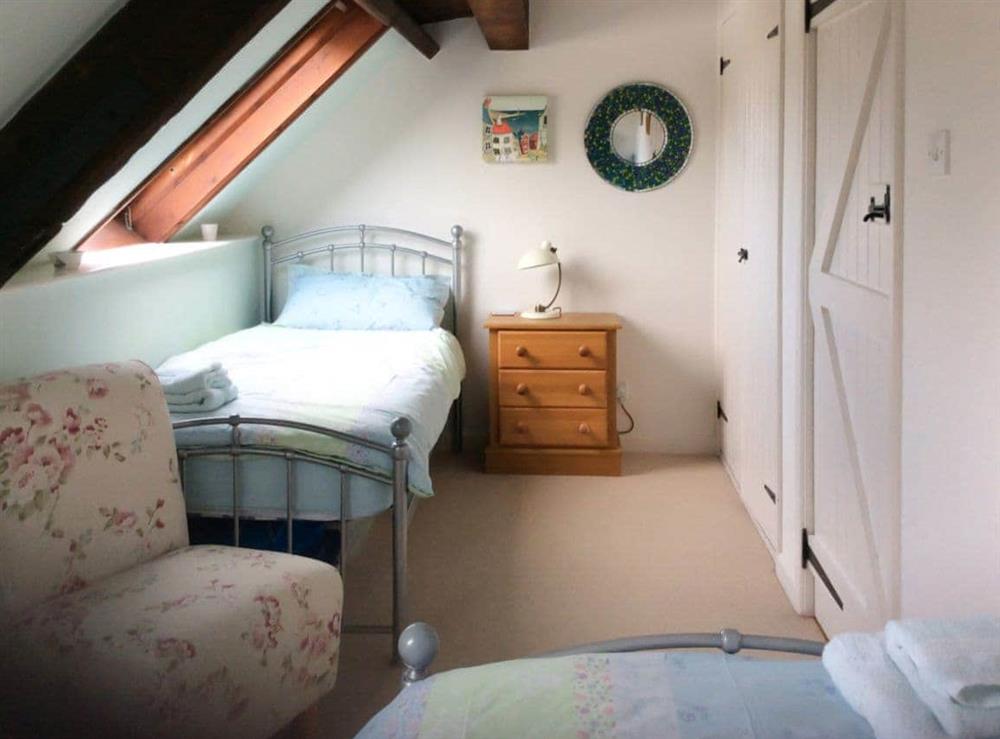 Twin-bedded room with sloping ceiling and Velux window at Clouseau Cottage in Lyme Regis, Dorset., Great Britain