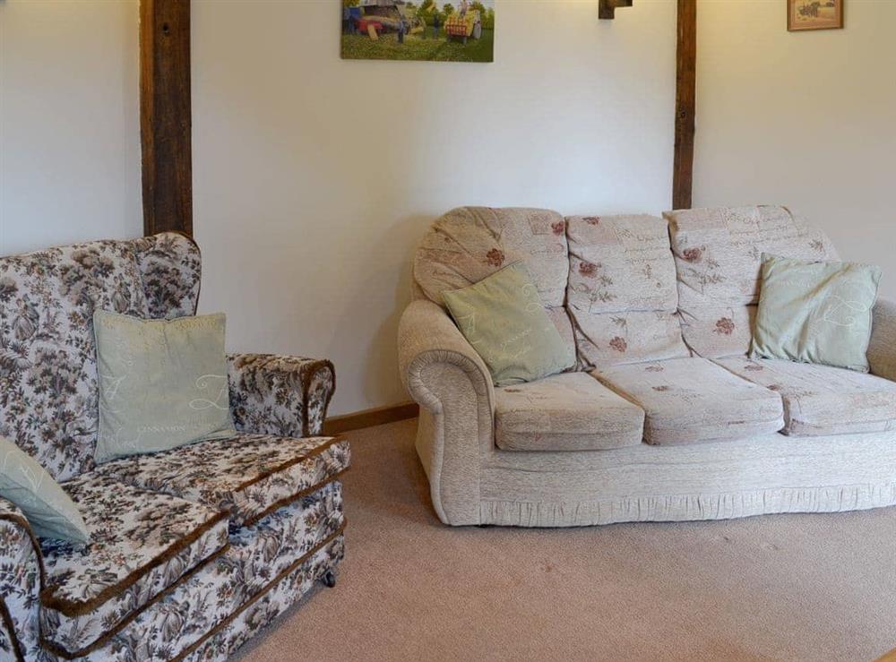 Comfy seating within living room at Clyst William Barn in Plymtree, Cullompton, Devon