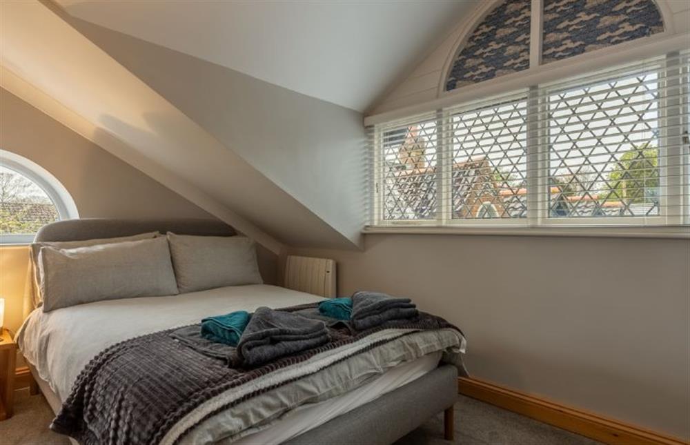 First floor: Bedroom with double bed at Coach House Cottage, Weybourne near Holt