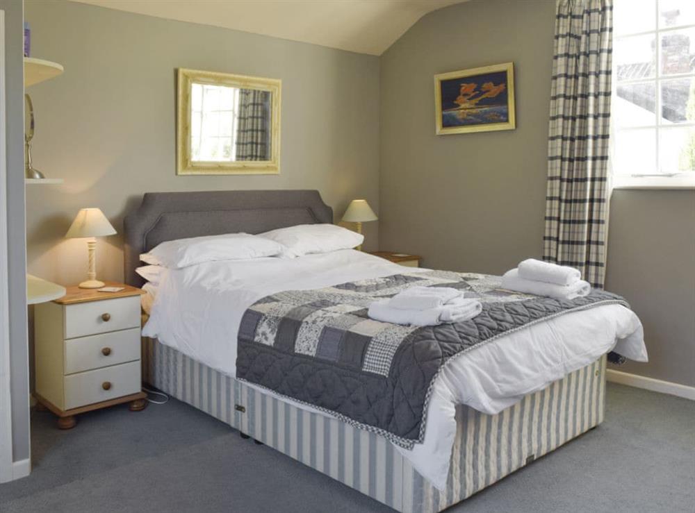 Comfortable double bed within living room at Coach House Annexe, 