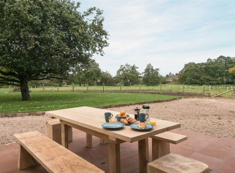 Enclosed, lawned garden with sitting-out area and garden furniture at Coach House in Greystoke, Cumbria