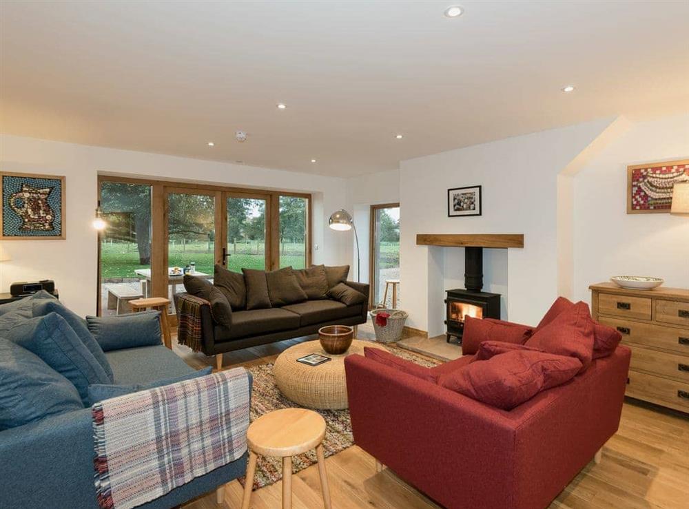 Living area with wood burner and French doors leading to garden at Coach House in Greystoke, Cumbria