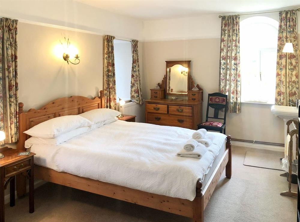 Comfortable bedroom with arched windows and washing facilities at Coach House in Loddiswell, Nr Kingsbridge, South Devon., Great Britain