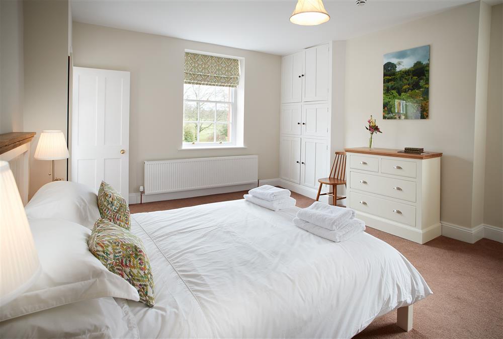 Bedroom one with a 5’ king-size bed at Coach House, Netherby Hall, Longtown