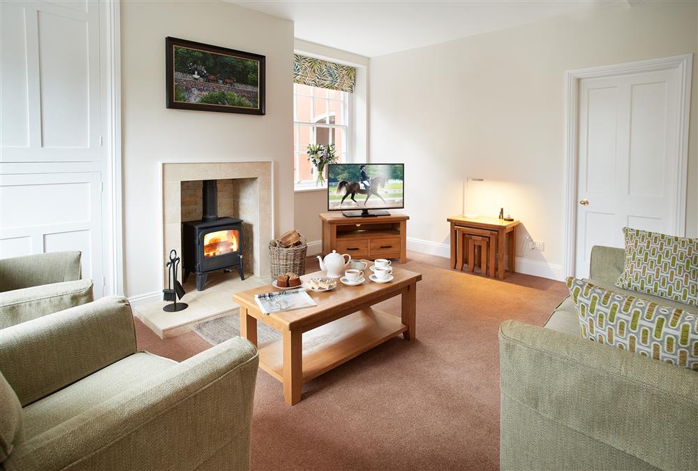 Sitting room with cosy wood burning stove at Coach House, Netherby Hall, Longtown