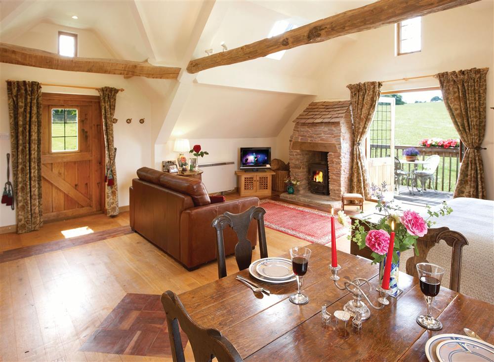 Open-plan sitting area with wood burning stove at Coach House (Worcestershire), Fishpools