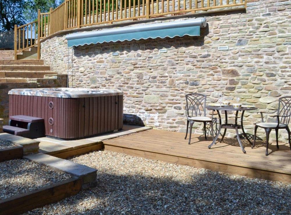 Courtyard with canopied hot tub and outdoor furniture at Coachmans Cottage in Fernilee, near Whaley Bridge, Derbyshire