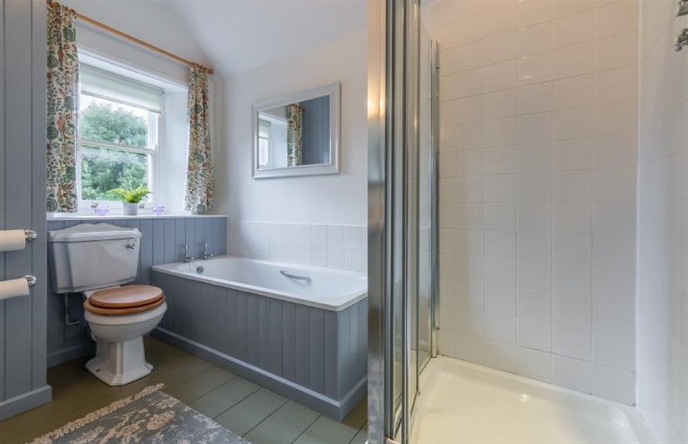 First floor: Bathroom with bath and shower at Coachmans Cottage, Old Hunstanton