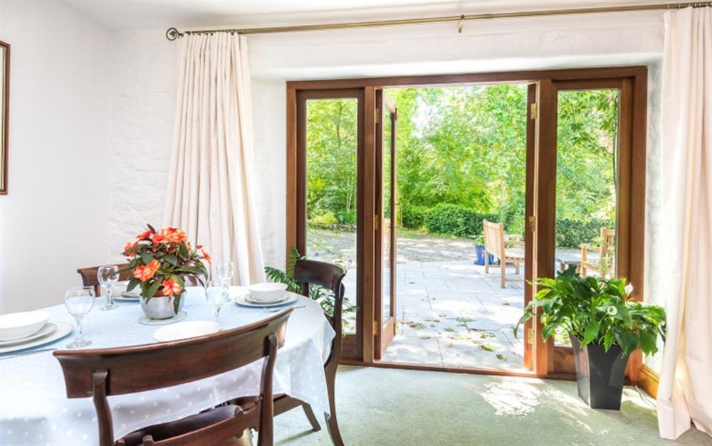 Dining area - fench doors leading out onto a large granite patio (photo 2) at Coachmans Cottage in St Kew