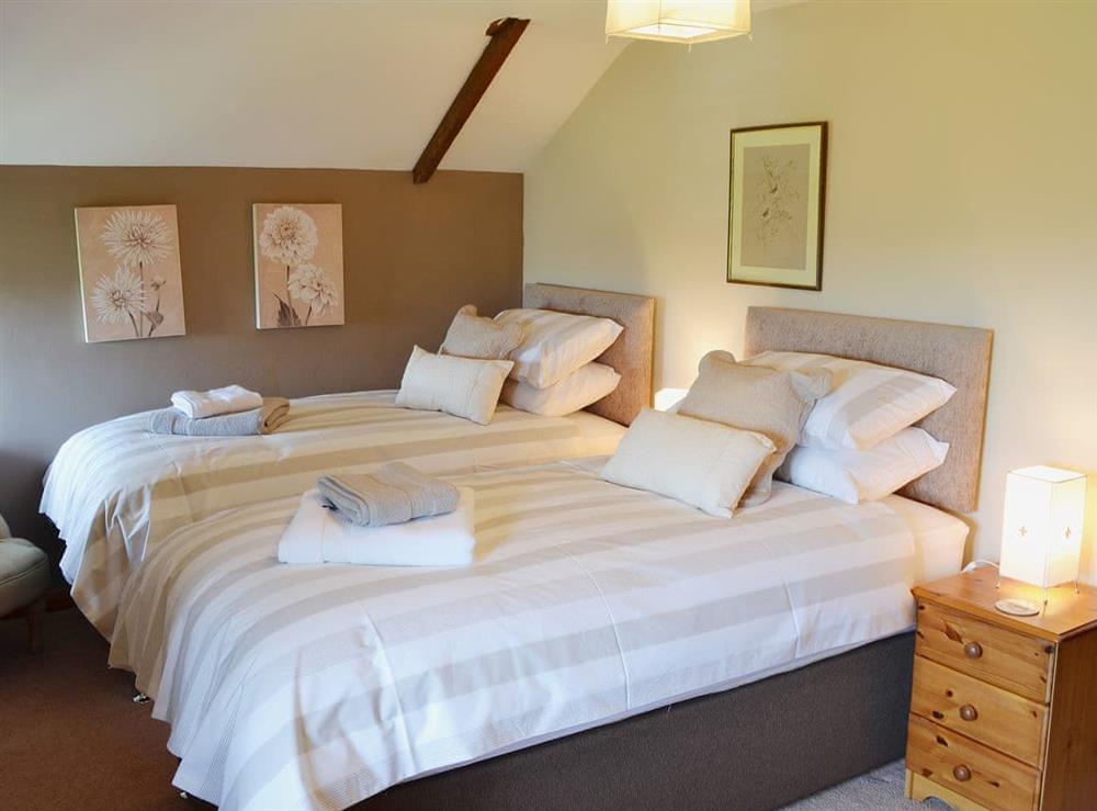 The cosy and romantic double bedroom has sloping ceilings at Coachmans Cottage in White Cross, near Newquay, Cornwall