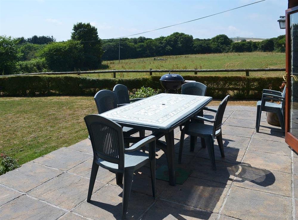 Paved patio area with table and chairs overlooking the garden at Coachmans Retreat in Pennytinney, St Kew., Cornwall