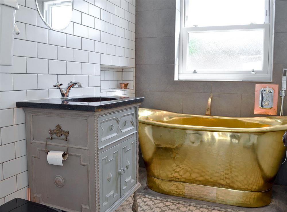 High-spec bathroom includes rare brass bath and copper sink at Coastguard Cottage in Swalecliffe, near Whitstable, Kent