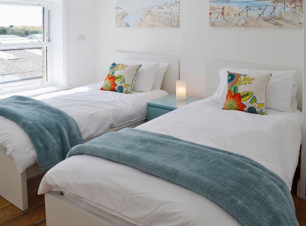 Twin bedroom with contemporary decor and crisp white linen at Coastguard Cottage in Swalecliffe, near Whitstable, Kent
