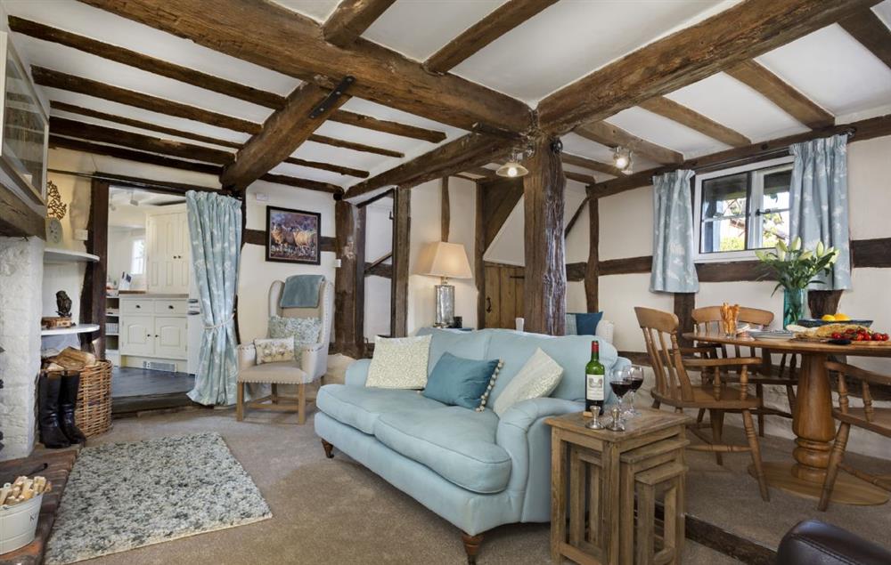 Sitting room with exposed beams, wood burning stove and raised dining area (photo 2) at Cobblers Cottage, Pembridge