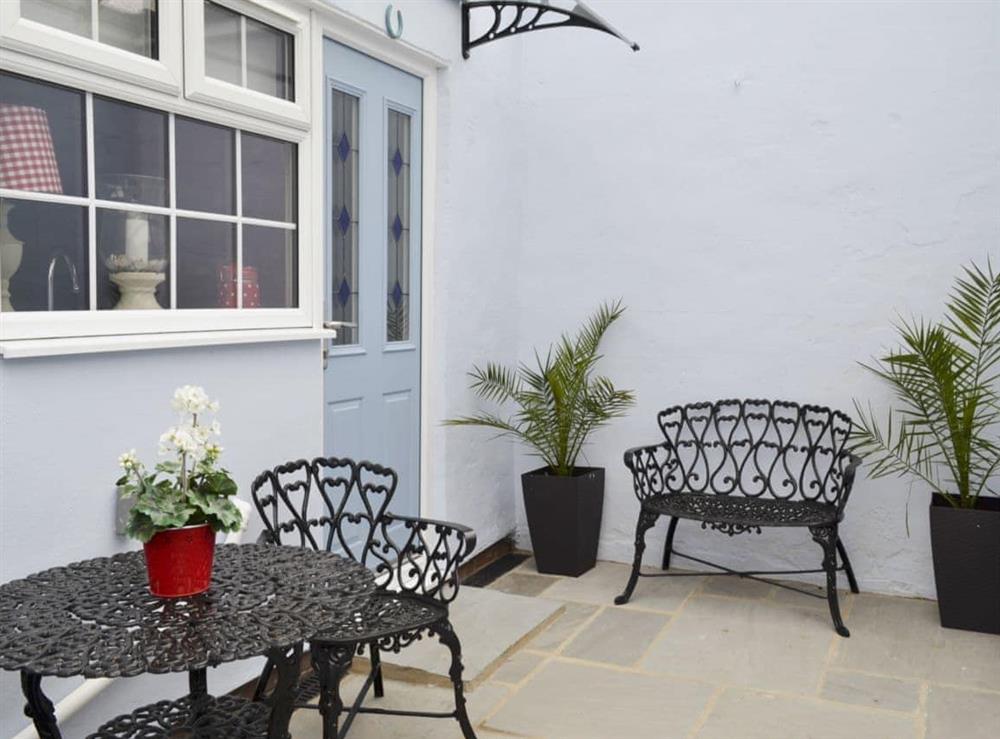 Small enclosed courtyard with sitting-out area at Coble Cottage in Filey, Yorkshire, North Yorkshire