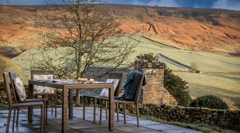 The patio with outdoor table and chairs at Cockayne Cottage in York, North Yorkshire