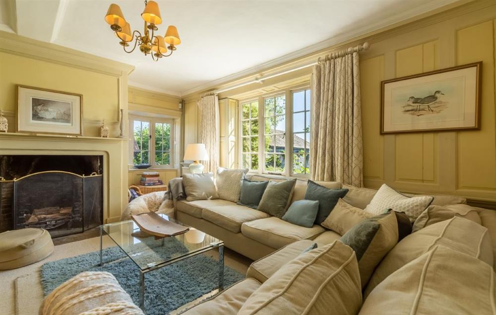 Snug with open fire, paneled walls and television at Cockerells Hall, Buxhall