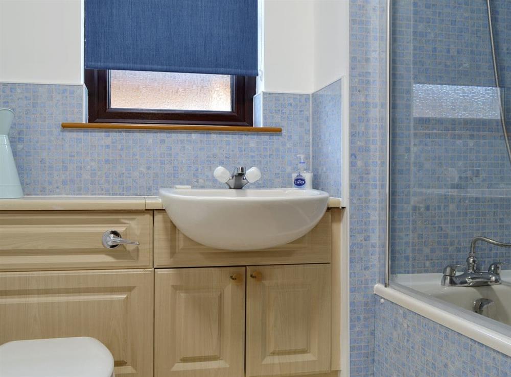 Family bathroom with shower over bath at Coiltie Cottage in Drumnadrochit, near Inverness, Inverness-Shire