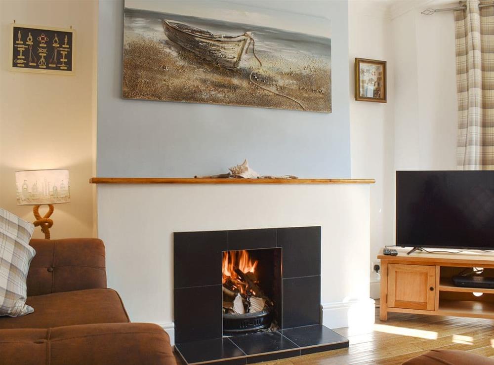 Charming living room with an open fire at Compass Point in Brixham, Devon