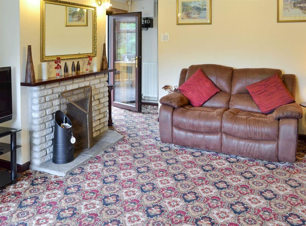 Spacious living room with open fire at Coombe End Cottage in Carn Brea, Redruth, Cornwall