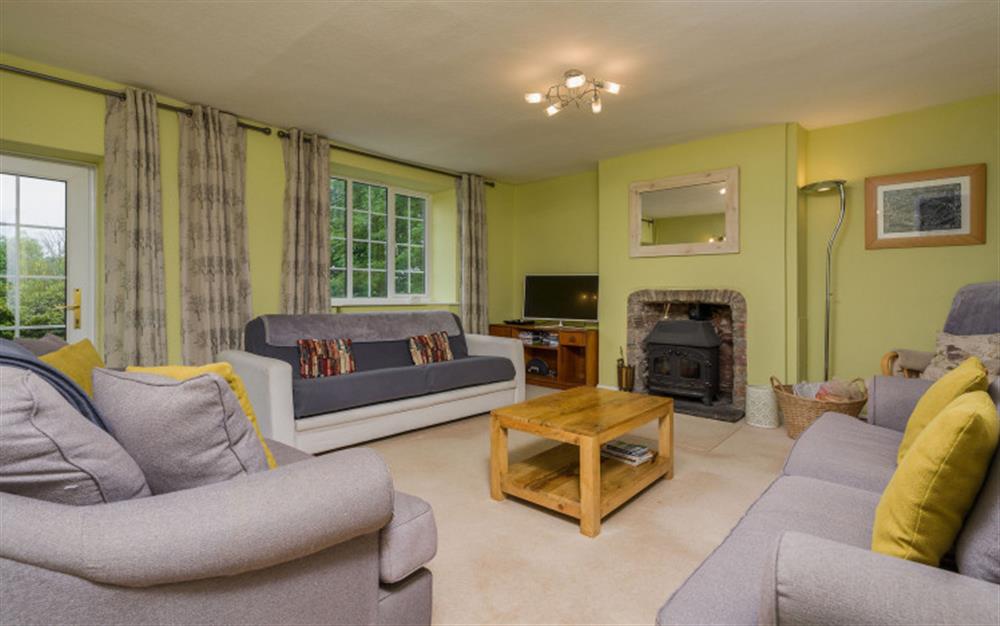 The living room with log burner, countryside views and access to the patio at Coombe Park in Chillington