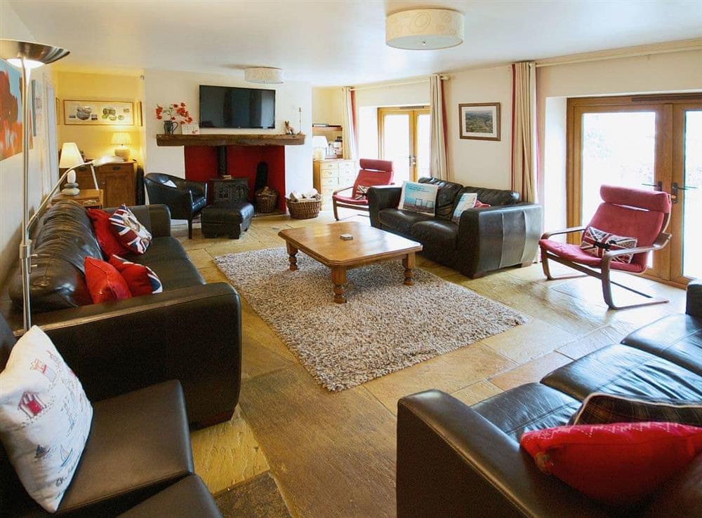 Large comfortable living room with French doors on to patio area at Coombehayes Barn in Uplyme, Nr Lyme Regis., Dorset
