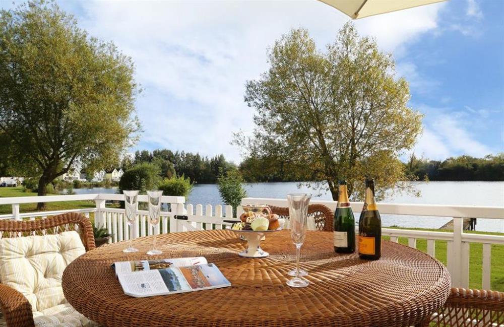 Outdoor furniture by the lake at Coot Lake House, Cotswold Lakes, Gloucestershire