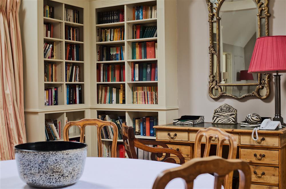 Bookcases surround the sitting and dining room at Cope Cottage, Bruern, near Chipping Norton