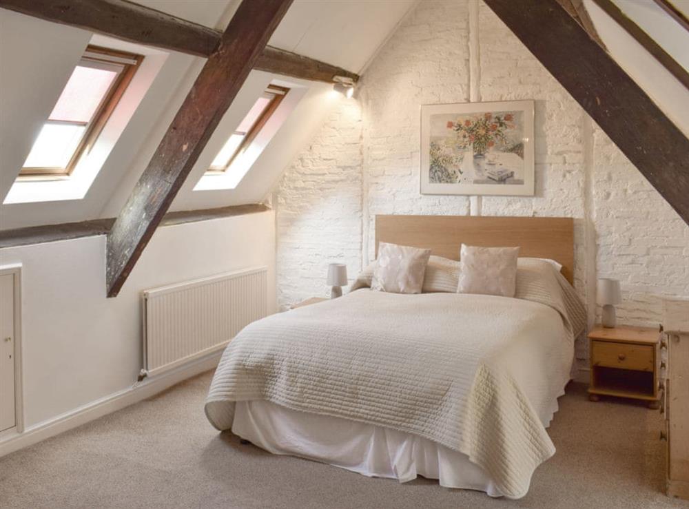 Upper floor double bedroom with exposed wooden beams at Cor Cottage in Whitby, North Yorkshire