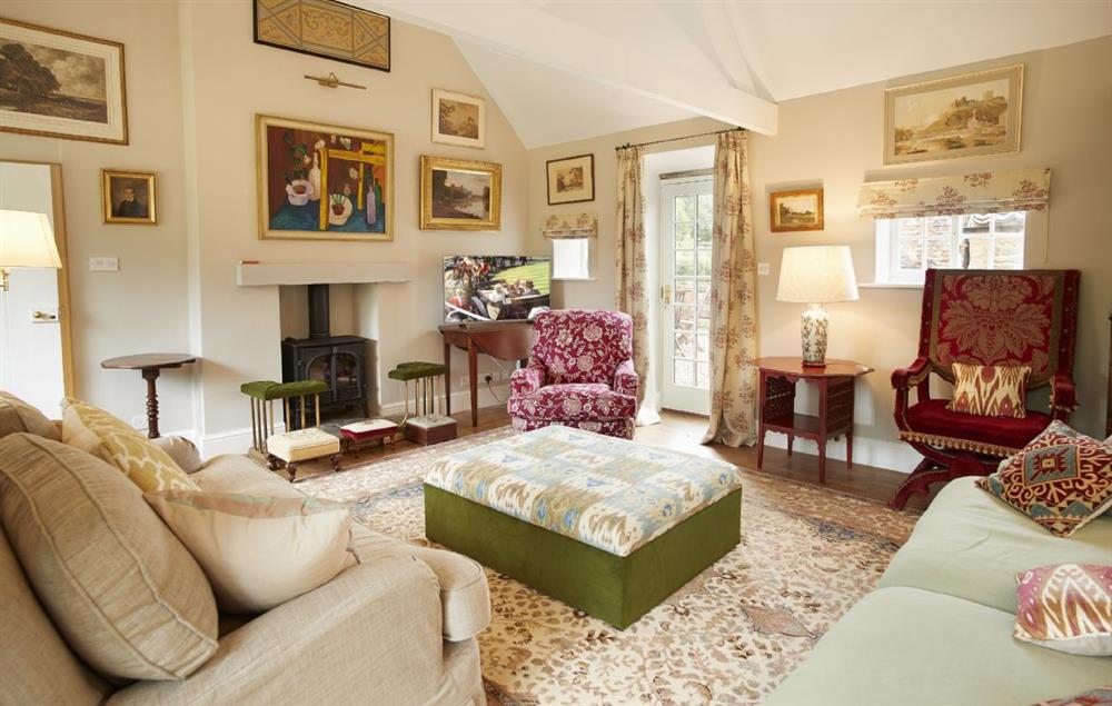 Comfortable sitting room with wood burning stove at Coral Cottage, Castle Howard
