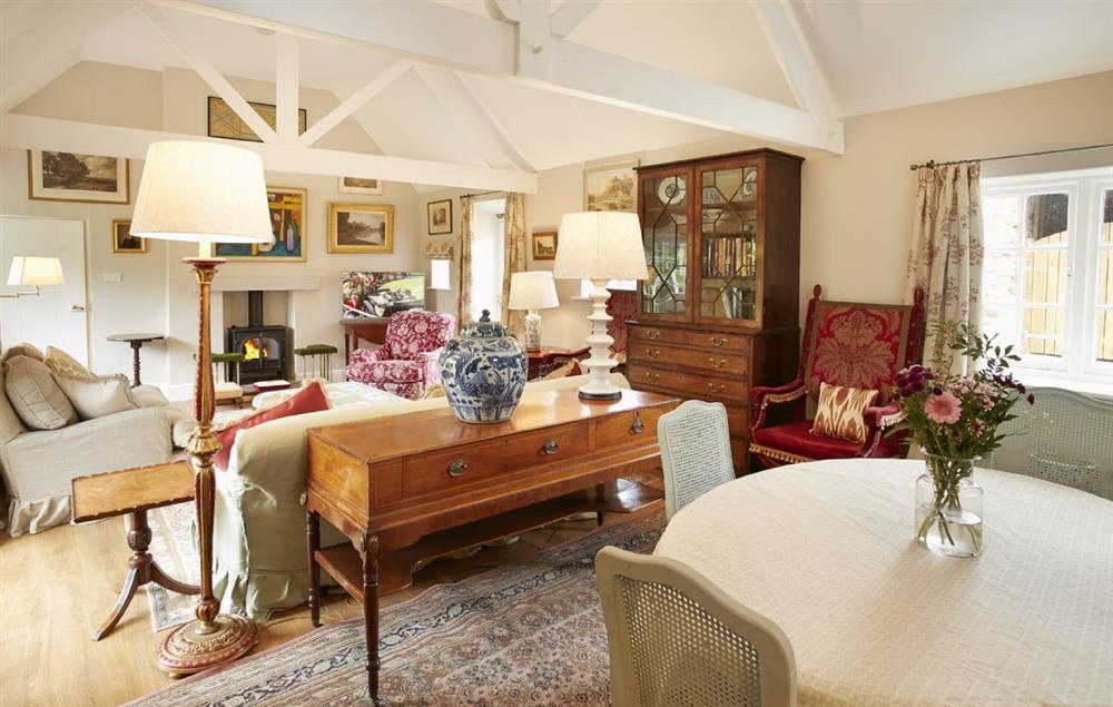 Sitting room with wood burner and dining area at Coral Cottage, Castle Howard
