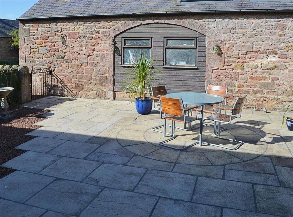 Flagged patio area with outdoor furniture ideal for al fresco dining at Corn Cottage in Belford, Northumberland., Great Britain