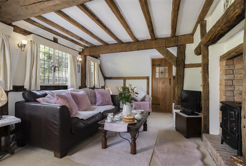 Sitting room with exposed beams, wood effect electric fire and original bread oven (photo 2) at Corner Thatch, Abbots Morton
