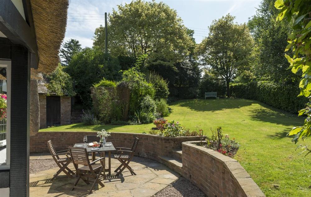 Steps from the patio area lead up to the large garden at Corner Thatch, Abbots Morton