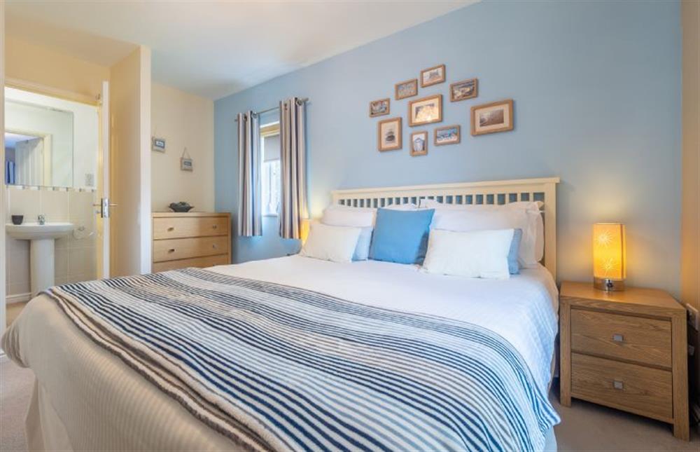 Master bedroom with king-sized bed, television and en-suite shower room at Cornish Fun, Duporth