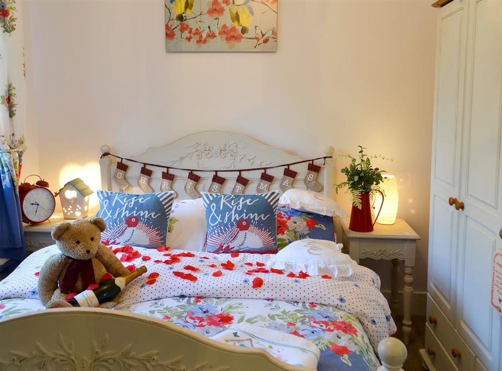 Cosy bedroom with French-style kingsize bed at Cosy Cottage at the Conifers in Amble, Northumberland