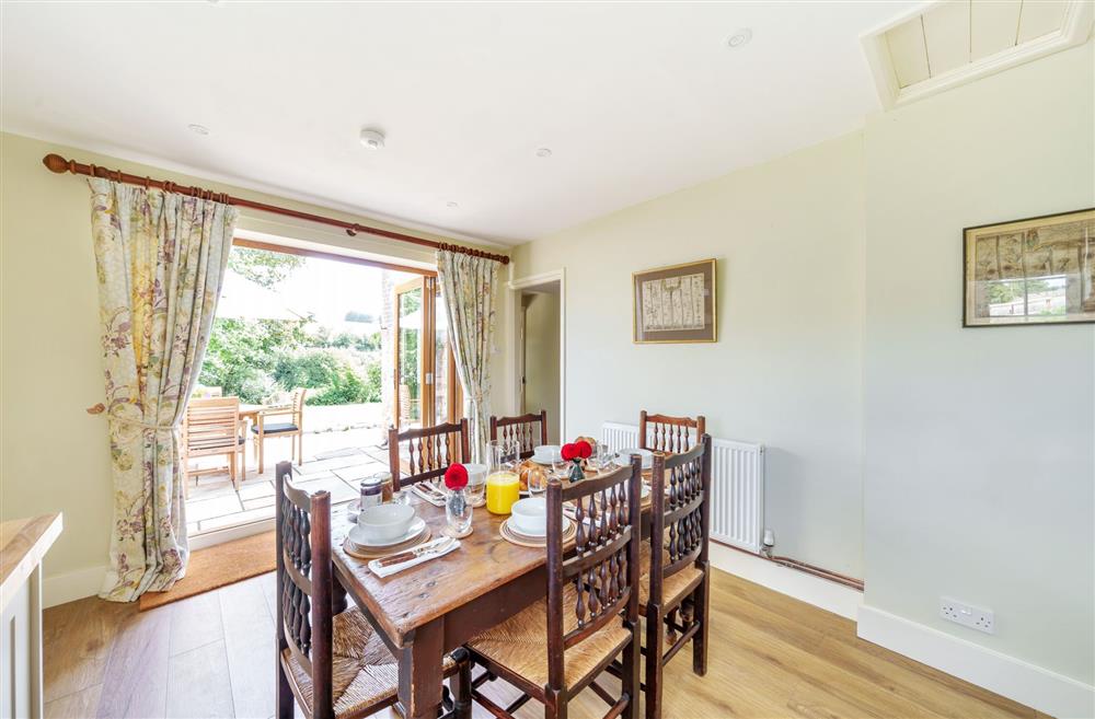 The dining area with access to the patio and beautiful rolling lawn at Cosy Cottage, Dorchester