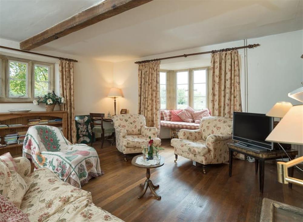 Living room with open fire, Freeview TV, grand piano, beams and wooden floor (photo 2) at Cotswold Way Cottage in Wood Stanway, near Winchcombe, Gloucestershire