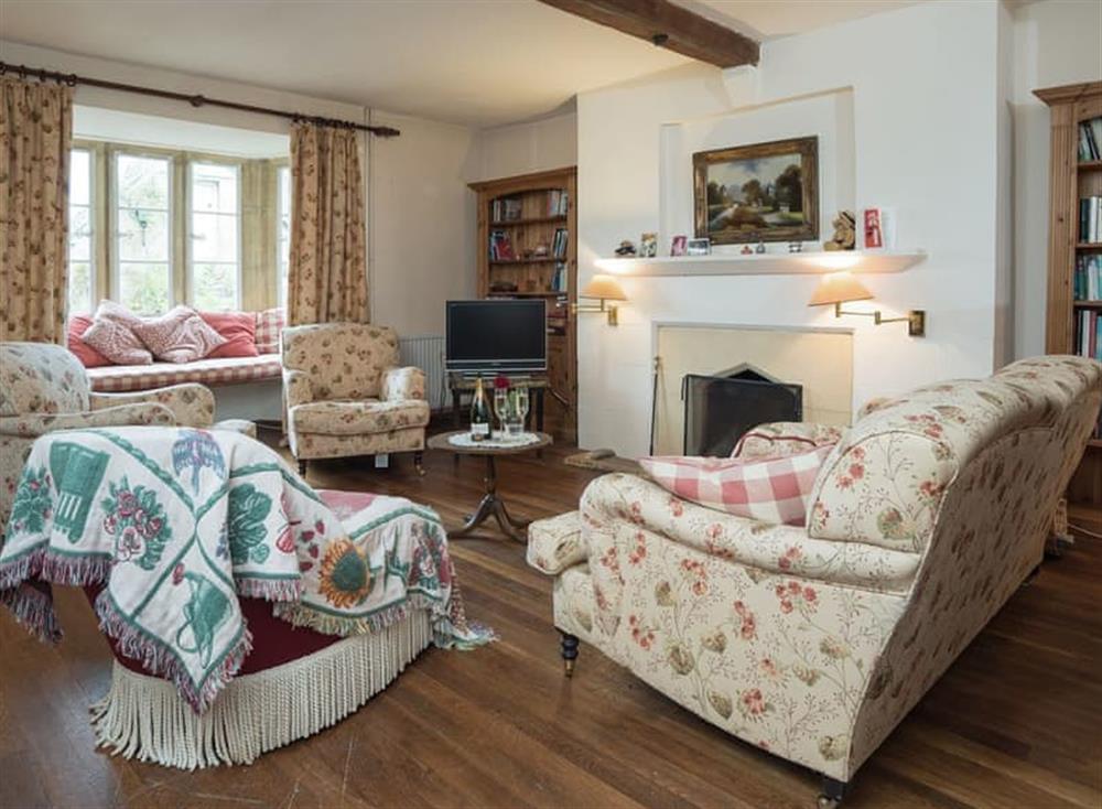 Living room with open fire, Freeview TV, grand piano, beams and wooden floor at Cotswold Way Cottage in Wood Stanway, near Winchcombe, Gloucestershire