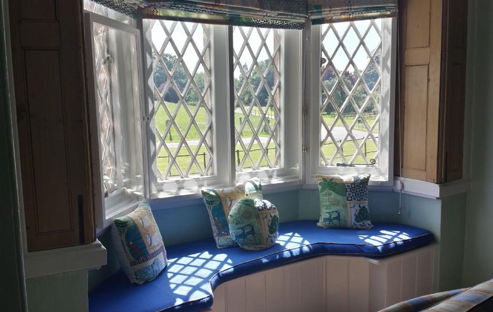 Sitting room with alcove seating overlooking the gardens at Cotton Cottage, Whitchurch