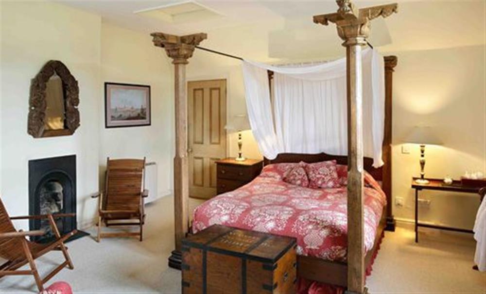 The double bedroom has its original fireplace, a splendid four poster bed and custom made furniture at Cotton Cottage, Whitchurch