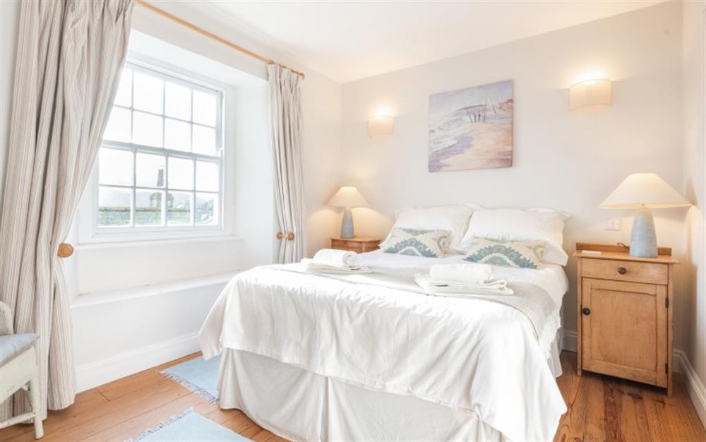 The master bedroom with double bed and en suite at Court Cottage in Salcombe
