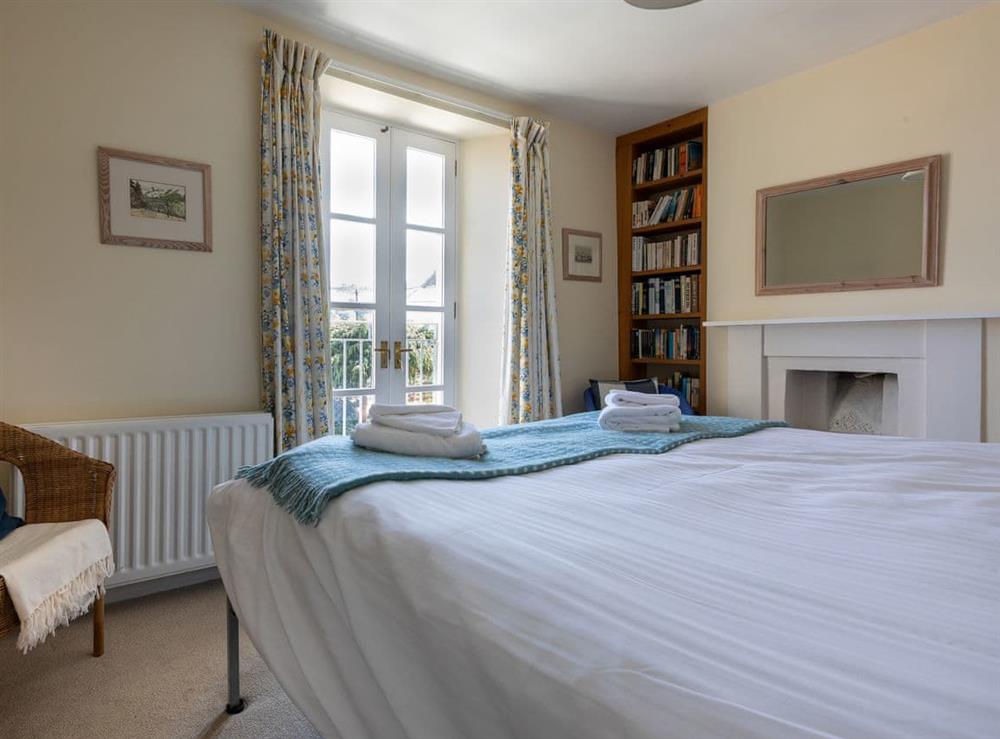 Bedroom with French doors and feature fireplace at Courtenay Street 5 in Salcombe, Devon